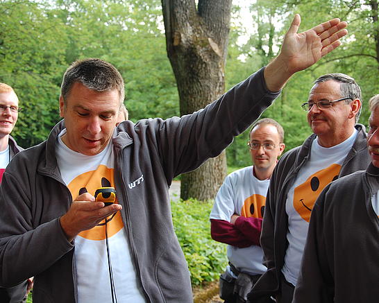 Ein Mann mit einer Stoppuhr gibt dem Rest der Gruppe ein Handzeichen