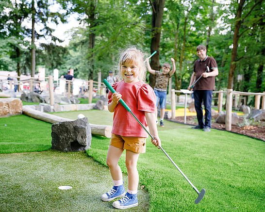 Ein Kind mit einem Minigolfschläger