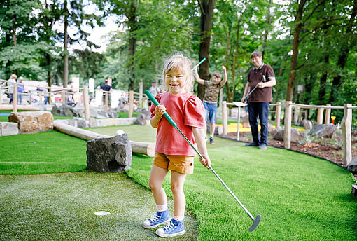 Ein Kind mit einem Minigolfschläger