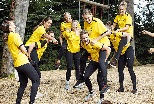 Spielerinnen von Borussia Dortmund lachen während einer Teamaufgabe