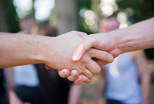 Zwei Menschen geben sich die Hand