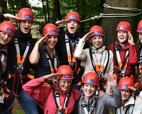 Eine Gruppe Kletterer freut sich im Kletterpark in Detmold, das sie eine Startzeit reserviert hat und keine Wartezeit hat