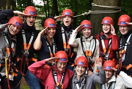 Eine Gruppe Kletterer freut sich im Kletterpark in Detmold, das sie eine Startzeit reserviert hat und keine Wartezeit hat