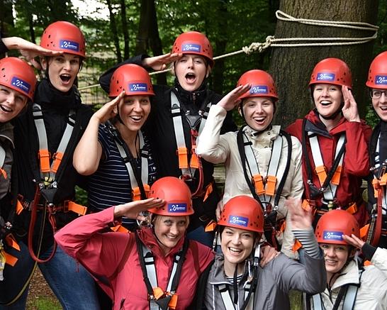 Eine Gruppe Kletterer freut sich im Kletterpark in Detmold, das sie eine Startzeit reserviert hat und keine Wartezeit hat