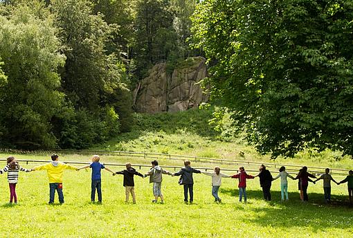 Eine Reihe von Kindern die sich bei der Hand halten