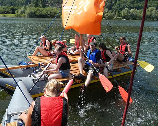 Ein Team unterwegs auf einem Fluss mit einem Floß