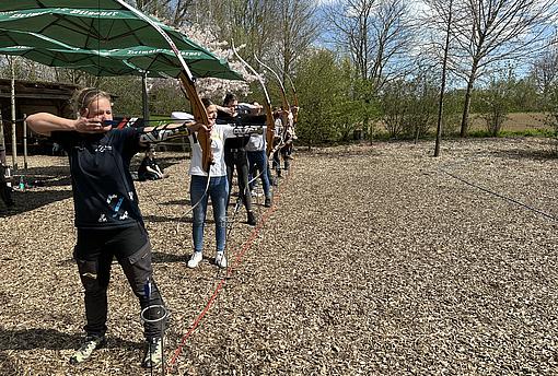 Eine Gruppe Menschen mit gespannten Bögen 