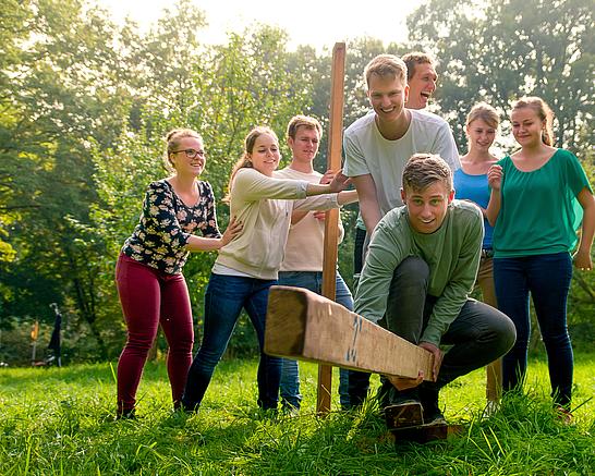 Eine Gruppe Auszubildender während einer Kooperationsaufgabe