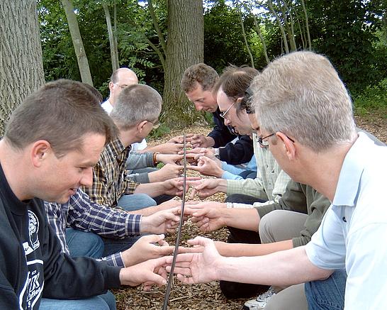 Eine Gruppe Männer trainiert ihre Teamfähigkeit