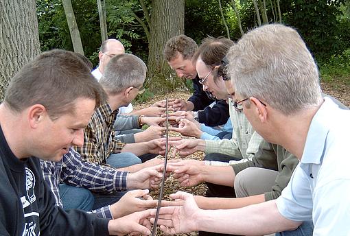 Eine Gruppe Männer trainiert ihre Teamfähigkeit